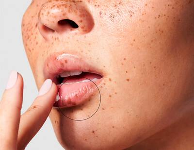 Mujer aplicandose producto SkinCeuticals para labios resecos