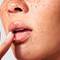 Mujer aplicandose producto SkinCeuticals para labios resecos