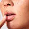 Mujer aplicandose producto SkinCeuticals para labios resecos